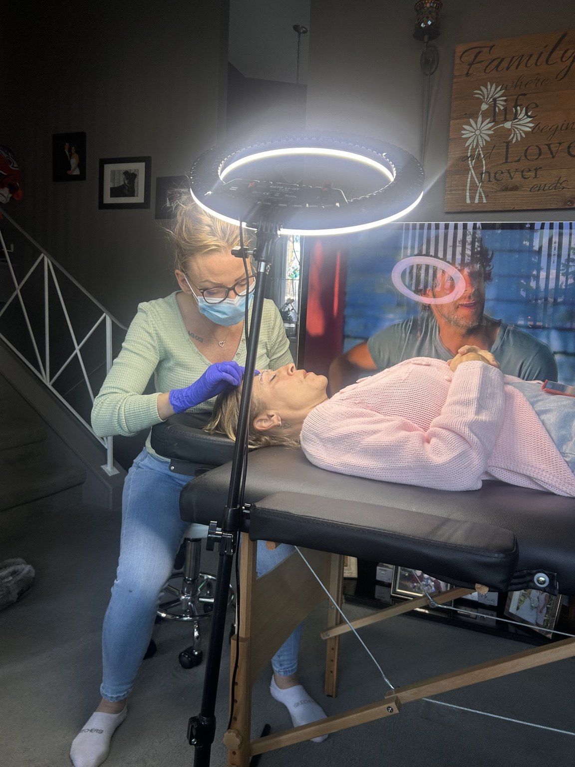 Amanda carefully performing a brow treatment with a ring light and portable treatment bed